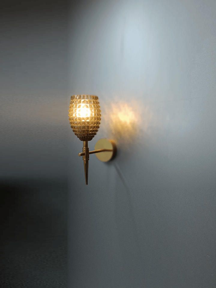 Crystal wall lamp casting a warm, inviting light in a hallway.