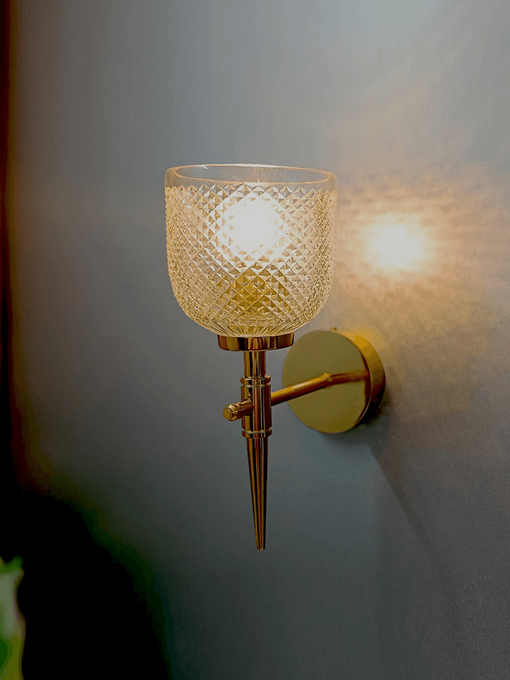 Create a stunning bedroom atmosphere with this gold PVD wall lamp and its sparkling crystal glass.