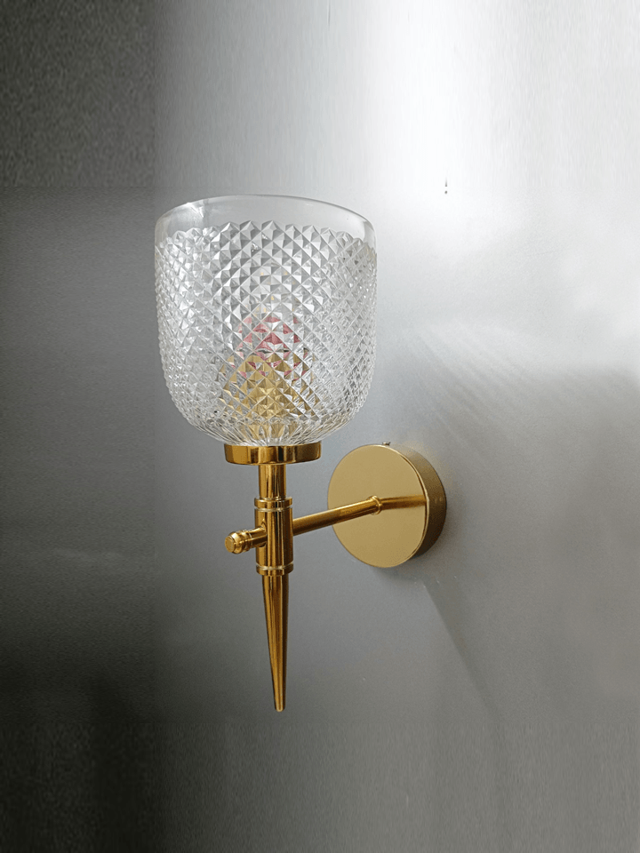 Bedroom wall sconce featuring a gold PVD finish and hand-cut crystal glass for a touch of elegance.