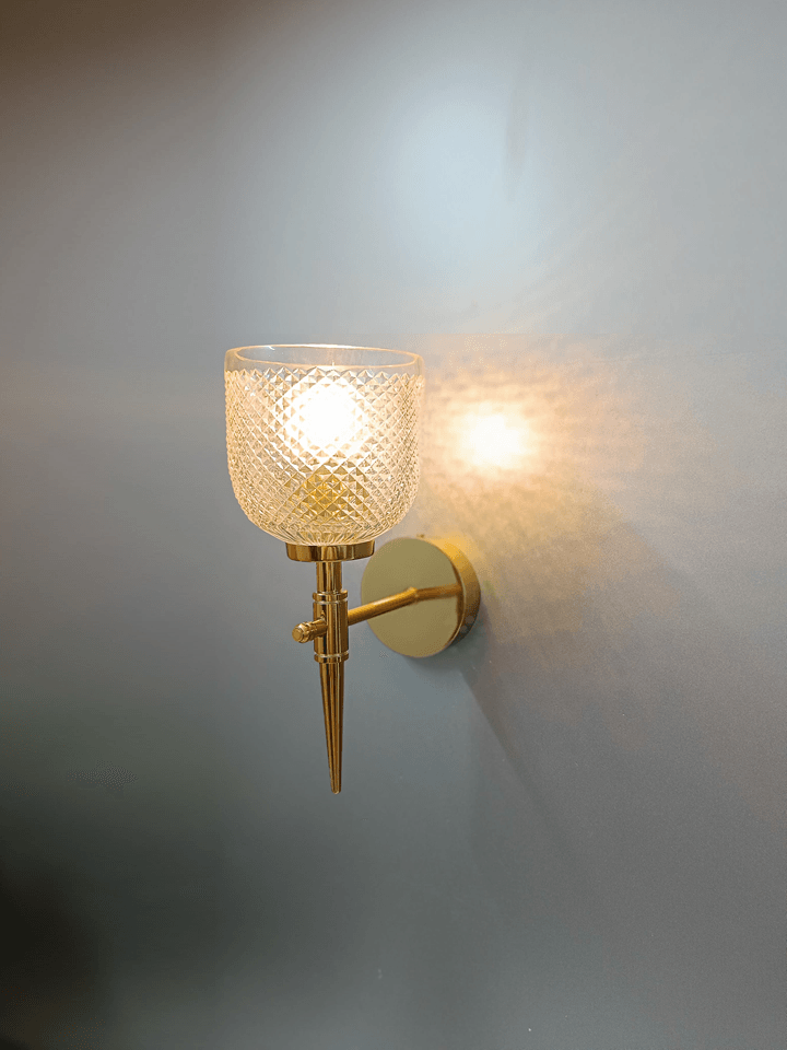 Gold PVD wall lamp with clear, hand-cut crystal glass for bedroom.