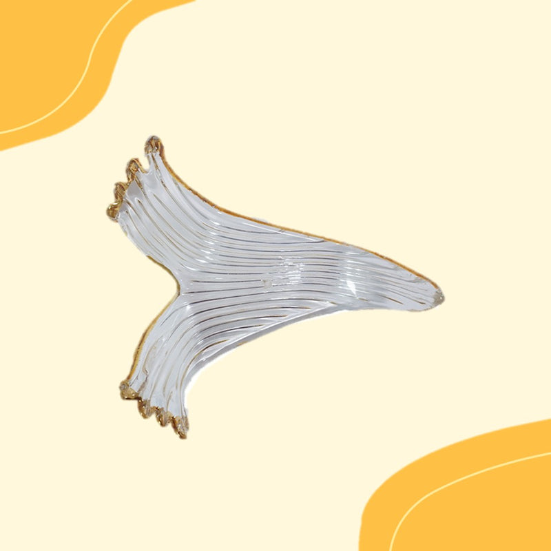 Decorative glass piece with gold accents on a yellow background