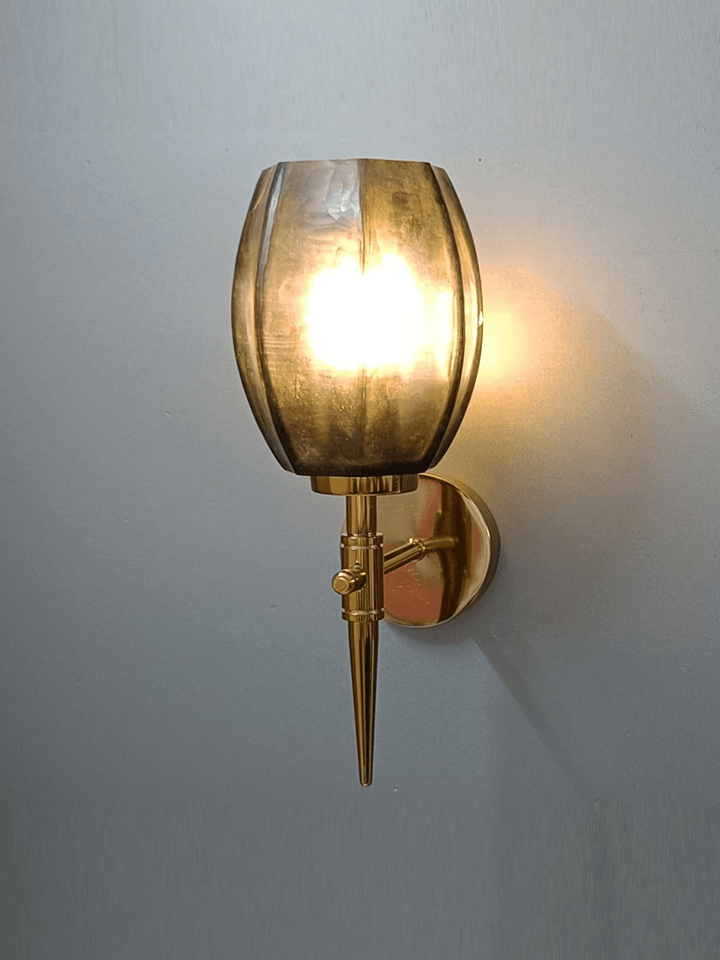 Relaxing on a sofa with a book illuminated by a gold wall light (India).