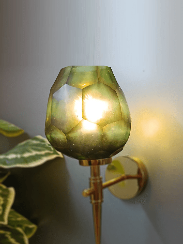 Modern gold wall lamp featuring an uneven, hexagonal diamond-cut dark green glass shade.