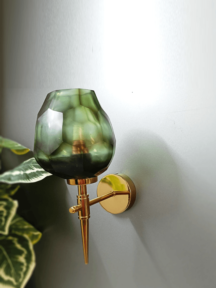 Uneven beauty! Gold wall lamp design with a dark green, diamond-cut glass shade.