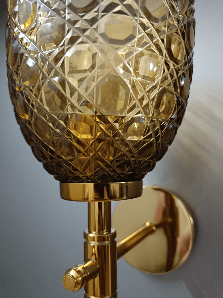 Diamond-cut champagne glass wall lamp with gold PVD finish, perfect for sitting room ambiance.