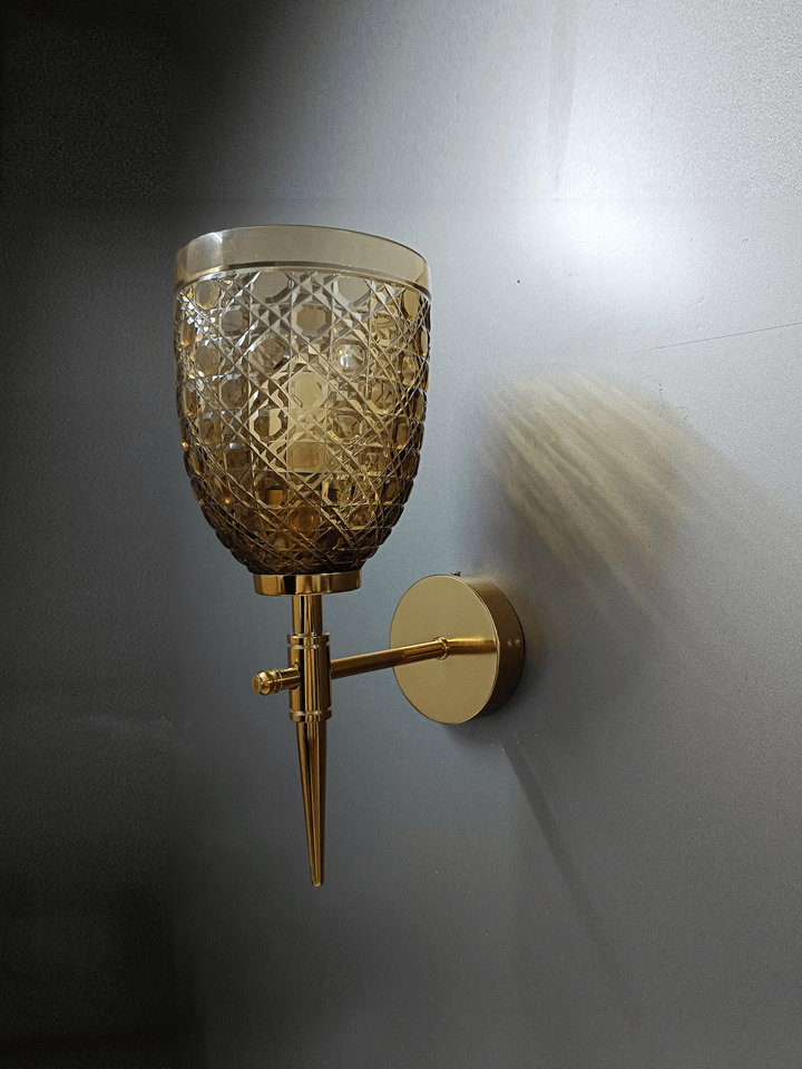 Wall lamp with gold PVD finish and hand-cut champagne glass, ideal for sitting rooms.