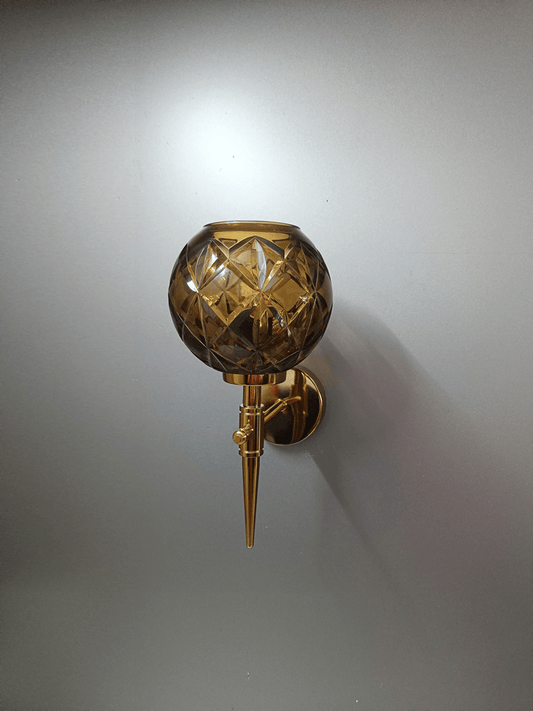 Luxurious gold PVD finish wall light with hand-cut crystal glass shade for bedroom (India).