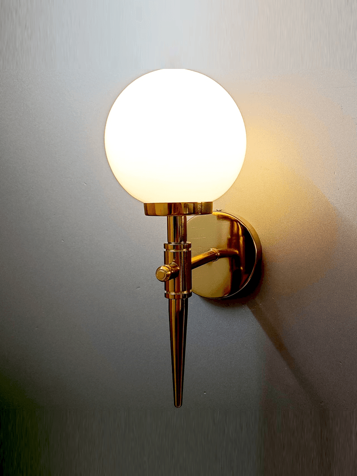 Luxurious gold PVD wall light with a perfect white, frosted opal glass ball for a cool ambiance.