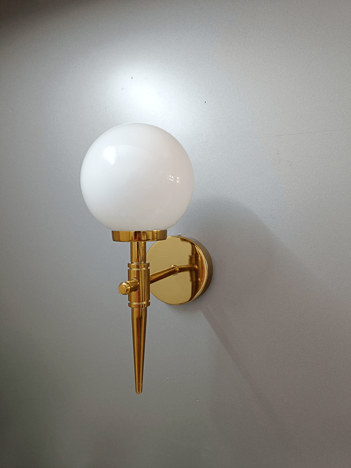 White frosted opal glass ball wall sconce with gold PVD finish, adding a touch of elegance.