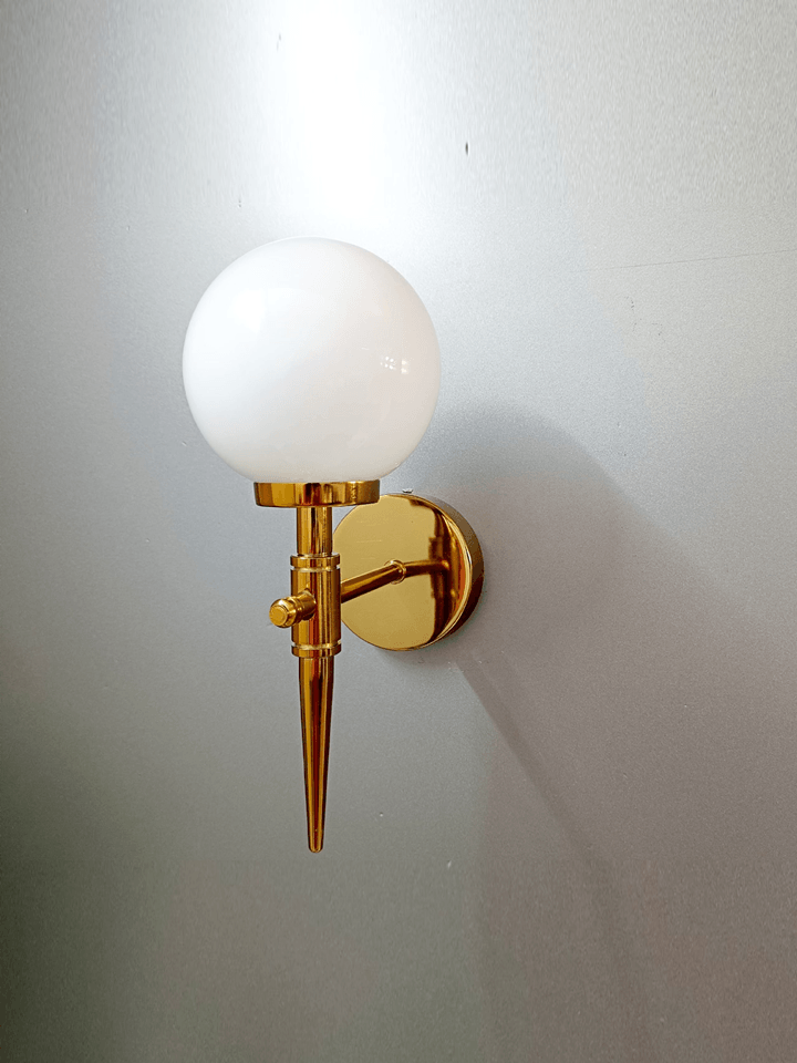 Modern wall sconce: gold PVD finish with a frosted opal glass ball, resembling a glowing orb.