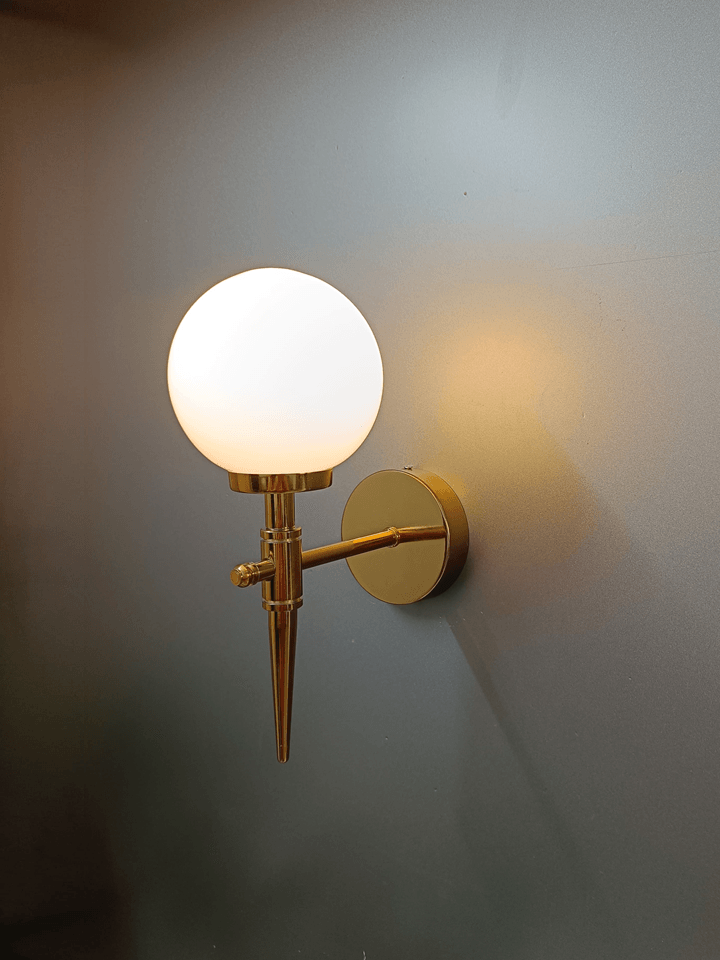 Modern wall light: gold PVD and a frosted opal glass ball for a touch of cool sophistication.