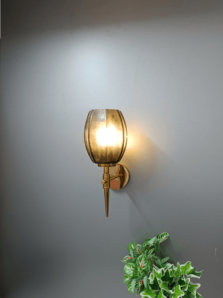 Gold wall light providing task lighting next to a living room sofa (India).