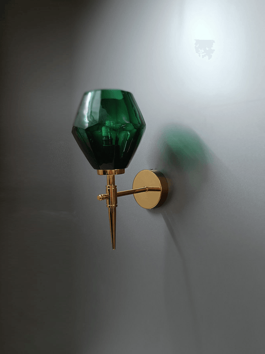 Green crystal wall light for home with a gold PVD finish, illuminating a living room. (Keywords: wall lights for home, green crystal wall light, gold PVD finish)