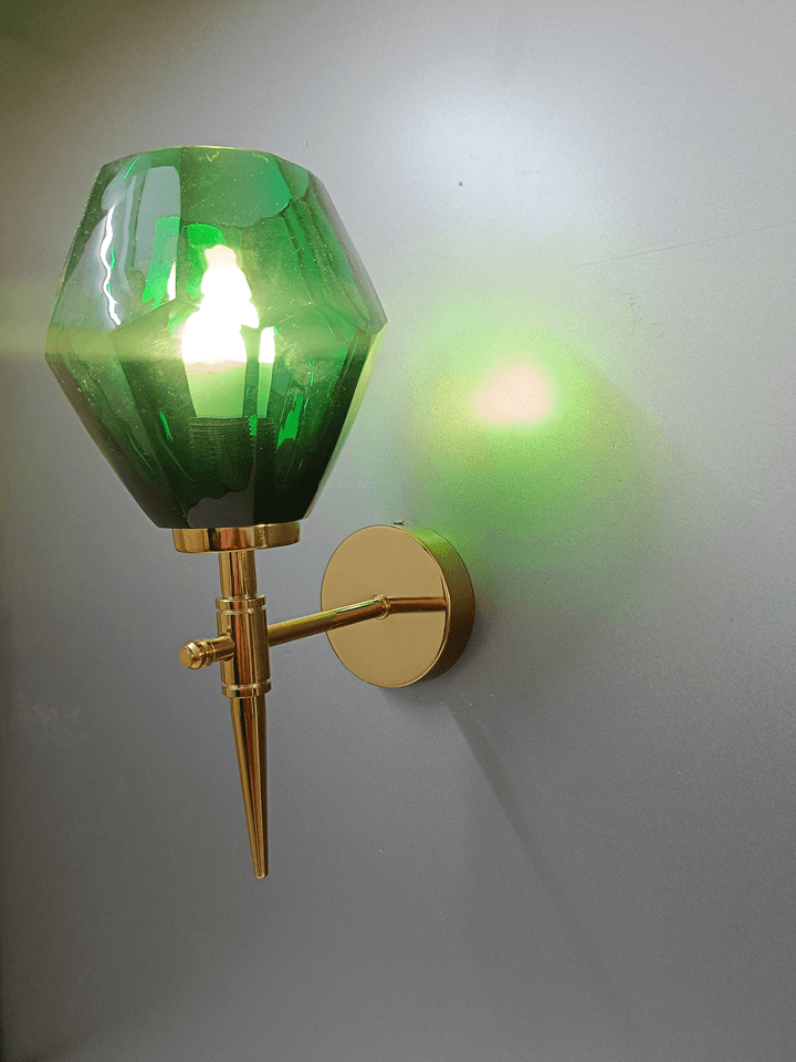 Green crystal wall light against a dark wall, highlighting the brilliance of the crystal. (Keywords: wall lights for home, green crystal wall light, dark wall)