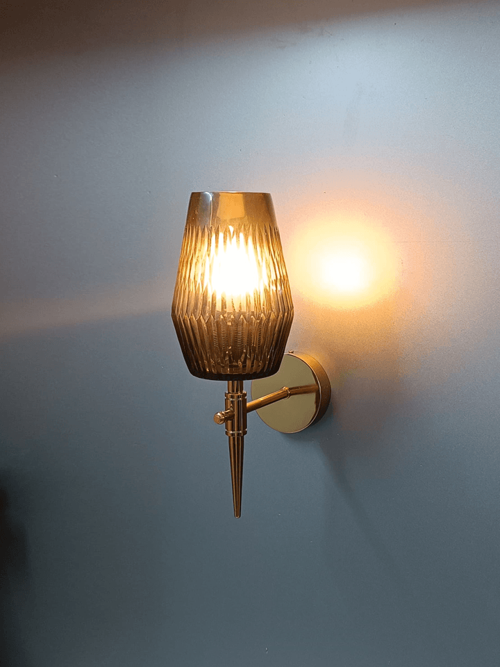 Transform your home decor with this luxurious gold PVD wall lamp, showcasing a black smoky glass shade with a diamond-cut design.