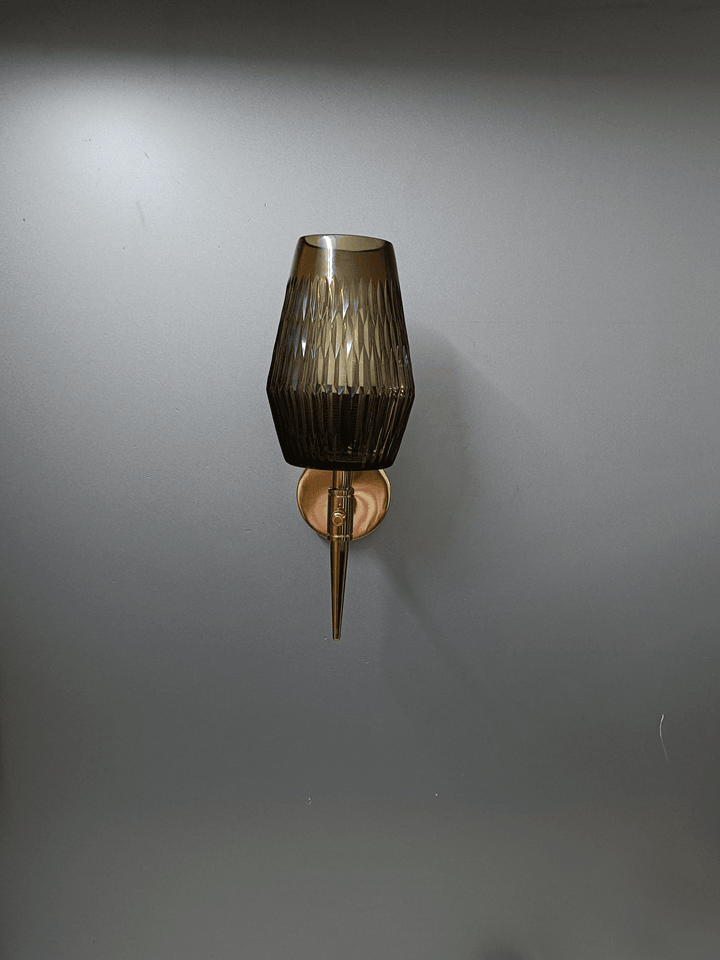 Decorative wall light with black smoky glass boasting a captivating linear ribbed diamond cut design, finished in a modern gold PVD.