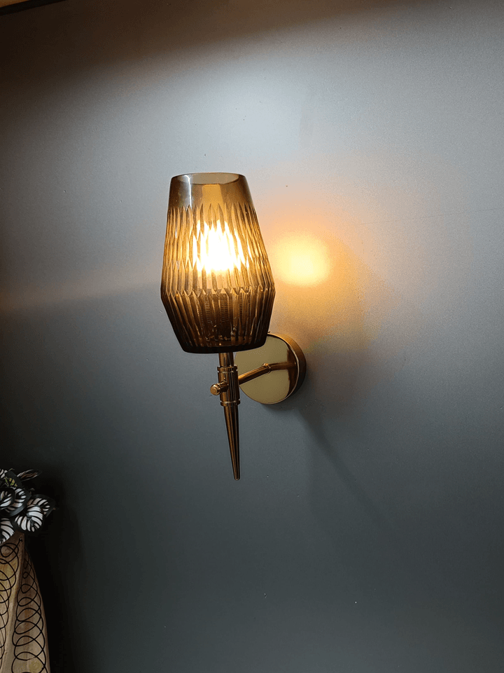 Create a dramatic and modern ambiance with this black smoky glass decorative wall light, adorned with a stunning diamond cut design and gleaming gold PVD finish.