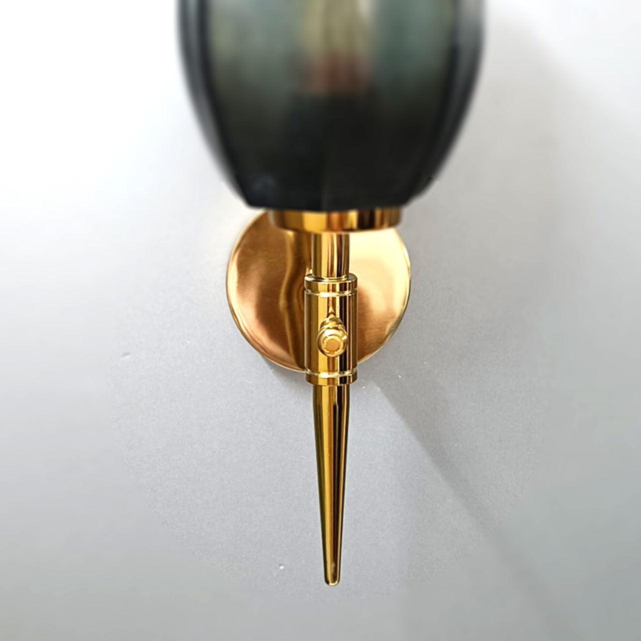 Close-up of a gold wall light with intricate design details.