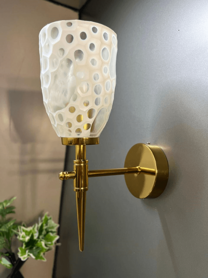 Modern wall sconce: gold PVD finish and diamond-cut crystal glass. 