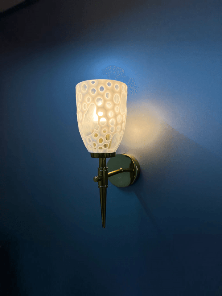 Gold PVD fancy wall light with diamond-cut crystal glass shade.