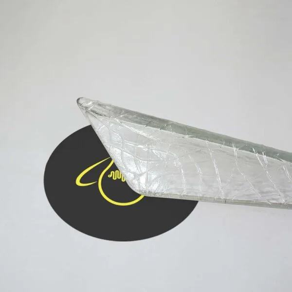Pointed tip of a crystal edge glass bar lifted at an angle, the clear borosilicate glass catching the light