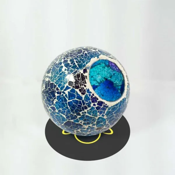 Close view of the opening of the blue crackle glass ball, with turquoise and blue glass inside