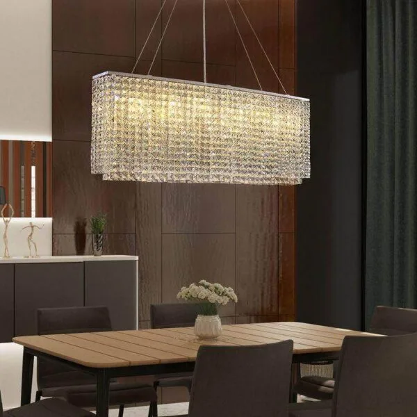 Oval crystal chandelier hanging on four steel wires over a wooden dining table in a dark wood-panelled room