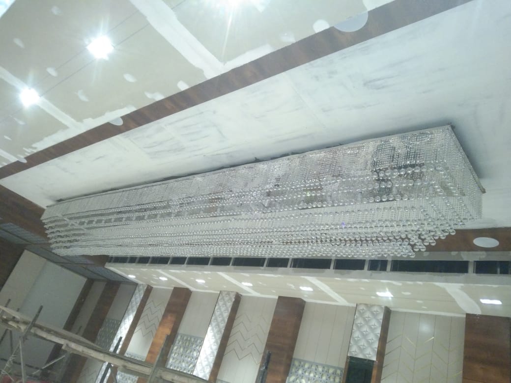 Unlit view of the banquet chandelier Pune project showing stepped crystal bead strands and 40mm crystal balls before wiring
