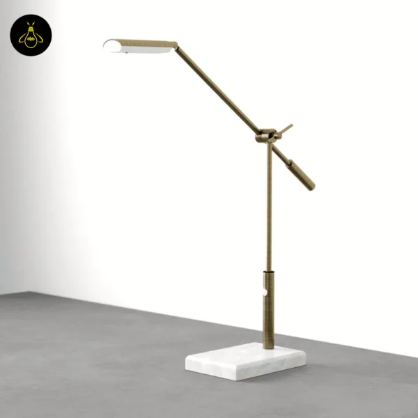 Close-up of the antique brass swing-arm desk lamp head and white marble base