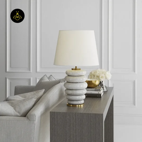 Stacked ceramic table lamp with white tapered linen drum shade and brass neck