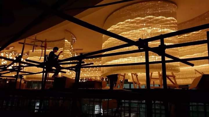 Warm-lit banquet chandelier installation at Luxe Cascade Pune during setup