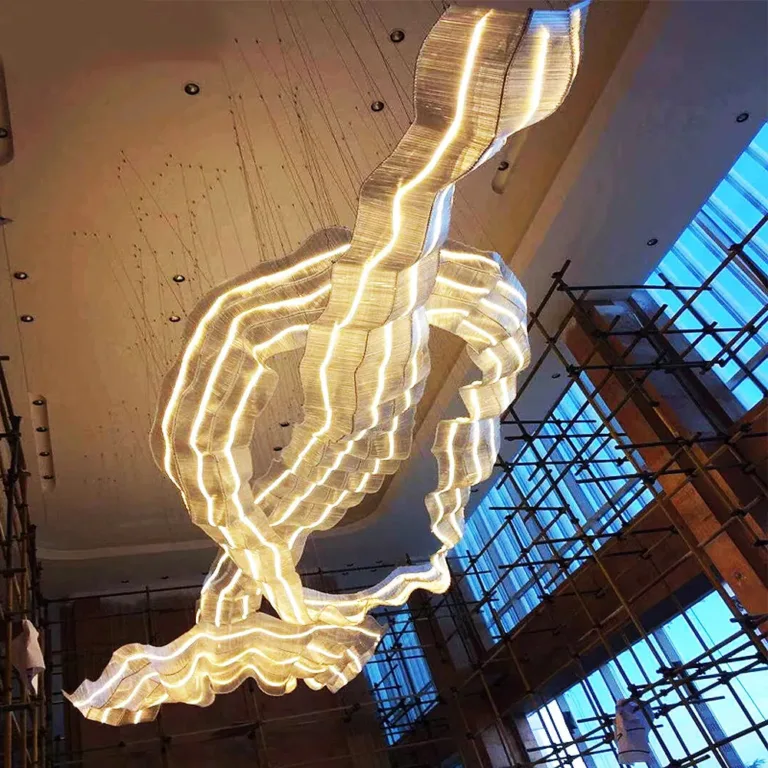 Large sculptural ribbon chandelier suspended in the StayWell Kerala hotel interior