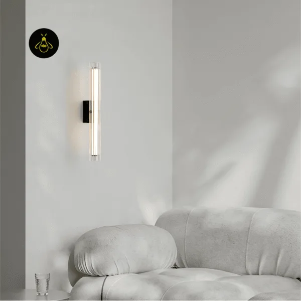 Fluted glass wall lamp glowing above a white sofa in a modern living room