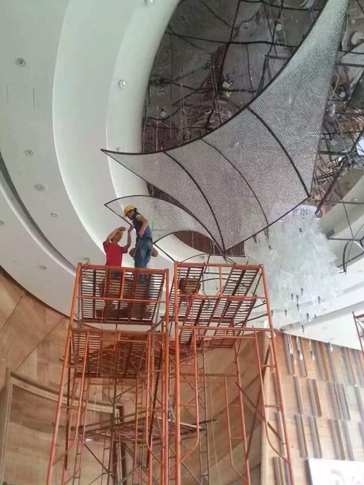 Installation-stage view of the large crystal lobby chandelier at Astra Lumina Mumbai