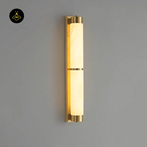 Alabaster wall light lit on a grey wall, warm glow showing natural veins in the stone