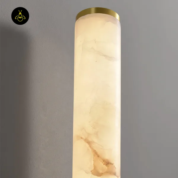 Close-up of the alabaster wall light: natural veining in the stone under a brushed gold end cap