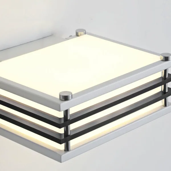 Wall sconces for bedroom: close-up of the Toast from above, white acrylic diffuser in a white stainless steel frame with black rails and polished steel posts