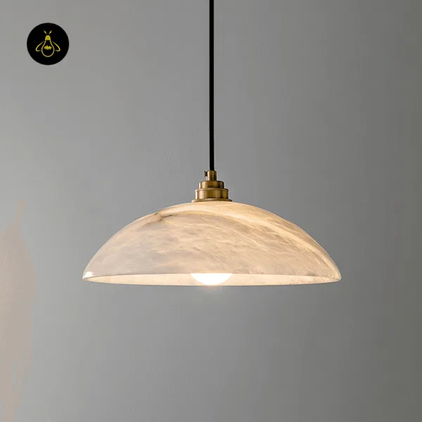 Lit alabaster hanging light against a grey wall, the glow showing the stone veins