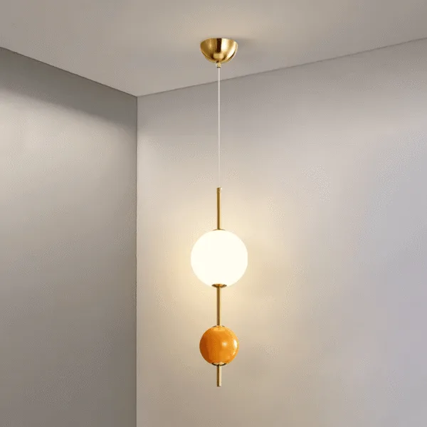 Round ball pendant light switched on in a room corner, opal globe glowing warm above the orange glass ball
