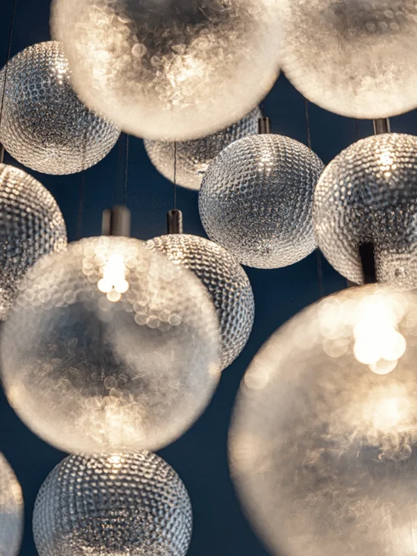 Close-up of warm-lit textured glass spheres and nickel connectors on the glass sphere chandelier