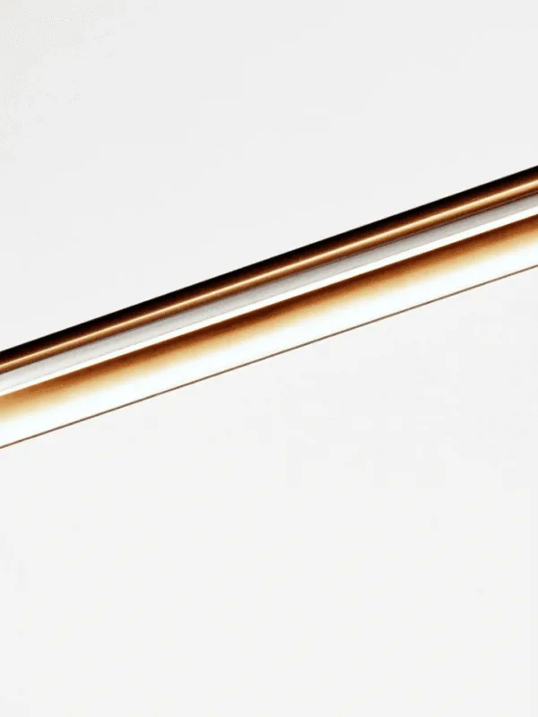 Close-up of brushed stainless steel finish on linear LED chandelier with warm glow