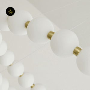 Close-up of matte white acrylic pearls joined by brass-finish connectors on the pearl chandelier
