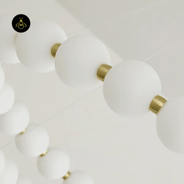 Close-up of matte white pearls joined by brass-finish connectors on the pearl chandelier