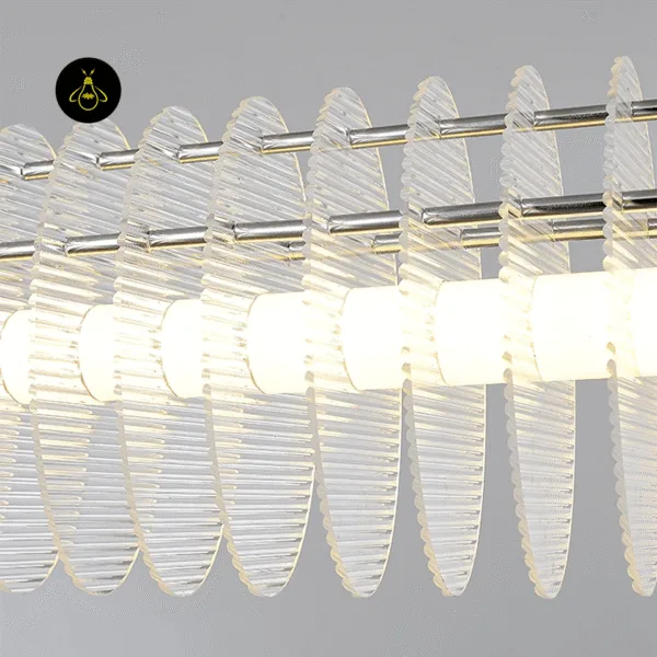 Close-up of clear acrylic discs on a linear LED chandelier diffusing warm light