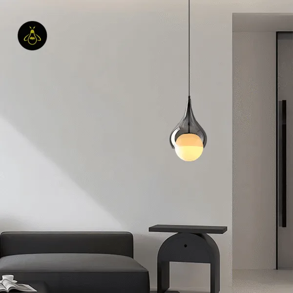 Hanging bedside light in smoked borosilicate glass hung beside a sofa and side table in a modern living room