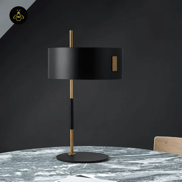 Black gold drum-shade table lamp on a marble table in a modern living room