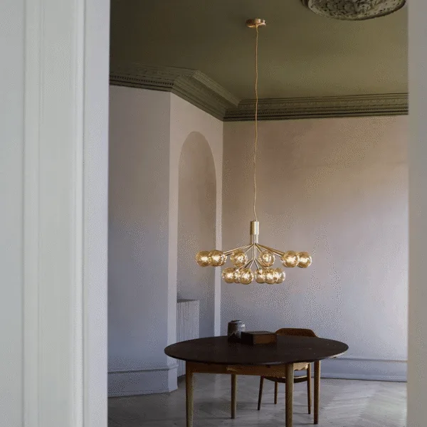 Brass glass globe chandelier hanging over a round wooden dining table