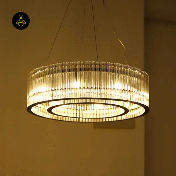 Illuminated modern ring chandelier glowing warm through its clear acrylic rods