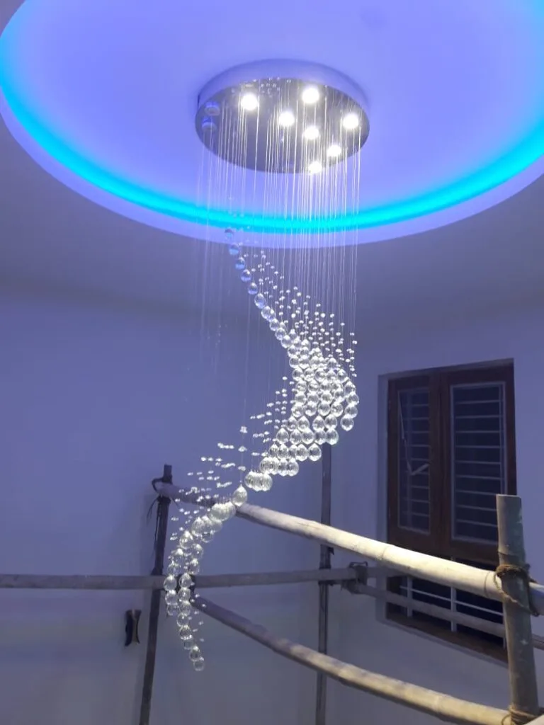 Tall crystal drop chandelier arranged in a twisting vertical form for a Ranchi residence