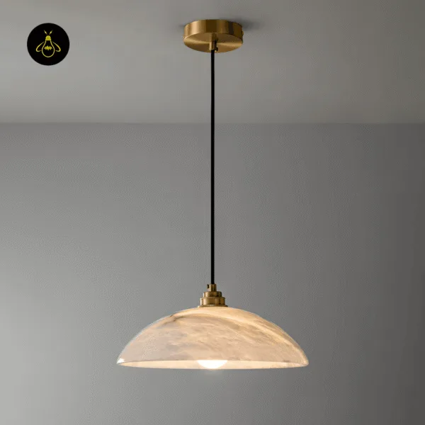 Alabaster hanging light with brass-finish ceiling canopy and black cord against a grey wall